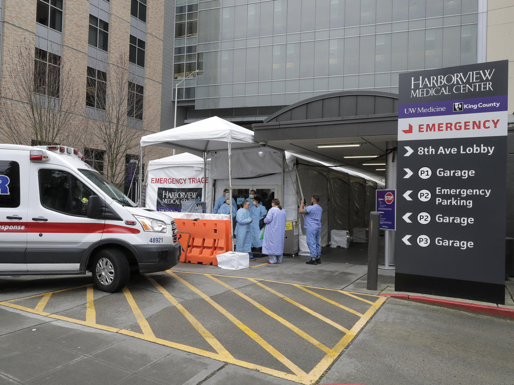 An ambulance pulls up as nurses outside a triage tent for the Emergency Department at the Harborview Medical Center in Seattle put on gowns and other protective gear at the start of their shift, on April 2, 2020. A resurgence of the coronavirus has health care workers and government leaders worried about dwindling resources and an exhausted workforce.