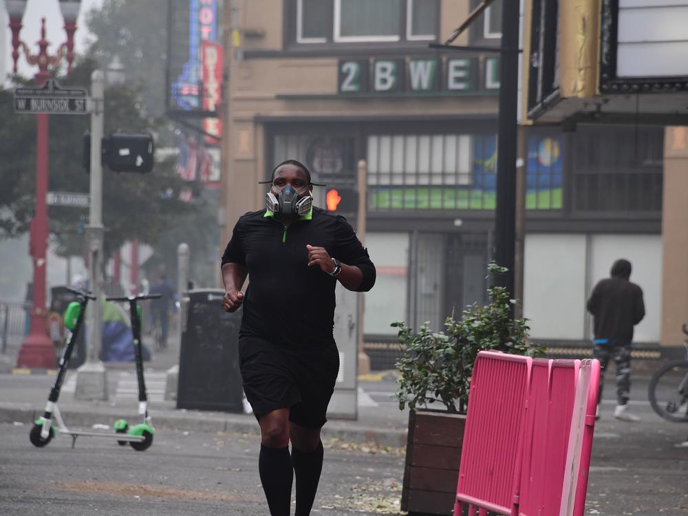 A Portland, Ore., resident wears a respirator to protect himself from wildfire smoke as he jogs in downtown in September 2020.