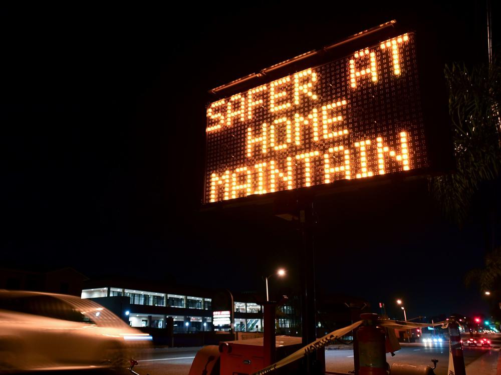 A sign reminds motorists of Los Angeles County's stay-at-home regulation. On Wednesday, the Centers for Disease Control and Prevention rolled out its revised guidelines for people potentially exposed to the coronavirus.