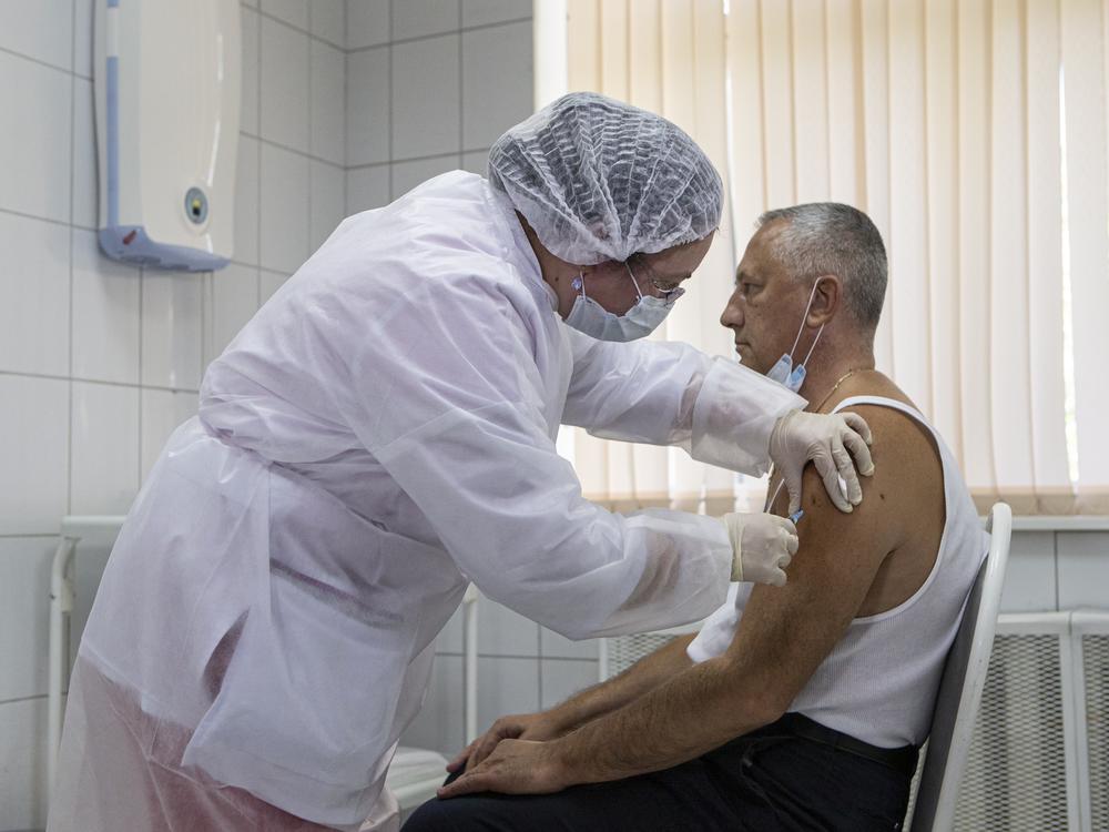 A Moscow health care worker administers a shot of Russia's Sputnik V coronavirus vaccine during clinical trials in September. President Vladimir Putin ordered the nation's health authorities to begin mass vaccinations next week.