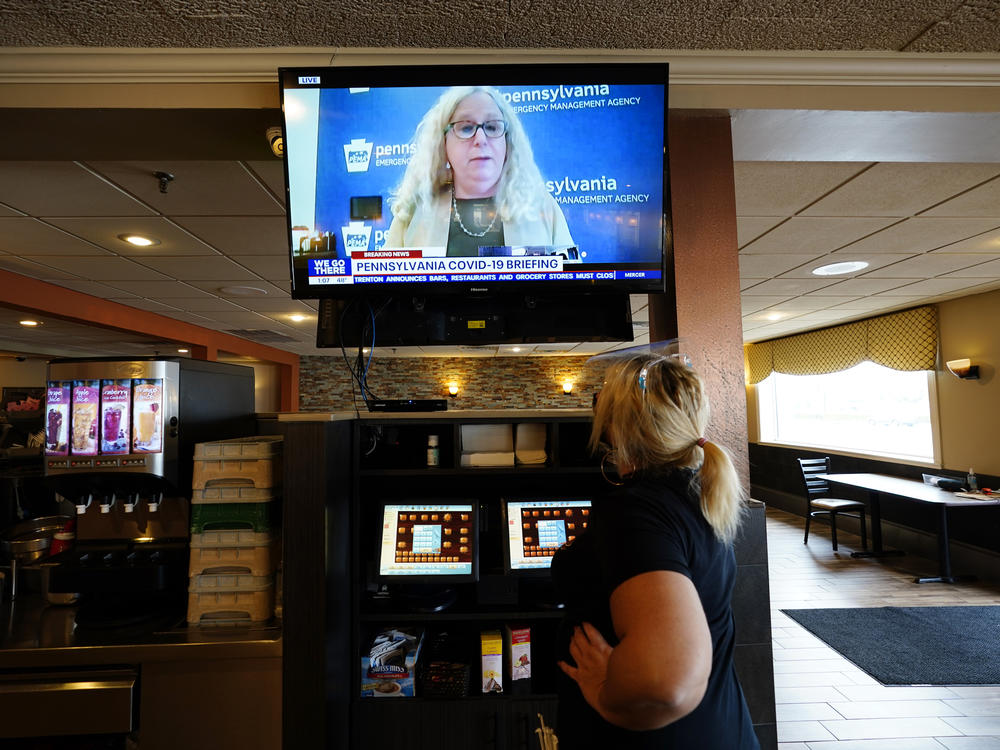 A waitress in South Philadelphia watches a television briefing by Pennsylvania's health secretary, Dr. Rachel Levine, on Nov. 17. Levine says a COVID-19 vaccine is 