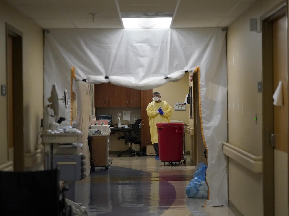 A doctor wears personal protective equipment while performing rounds in a portion of Scotland County Hospital set up to isolate and treat COVID-19 patients last month in Memphis, Mo.