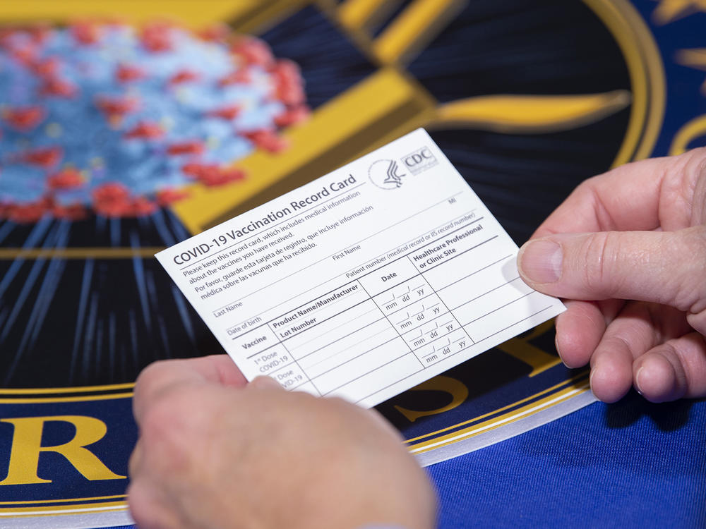 People getting the COVID-19 vaccine will receive a special vaccine card to record their doses, Operation Warp Speed officials say. Here, a Department of Health and Human Services employee holds a sample card.