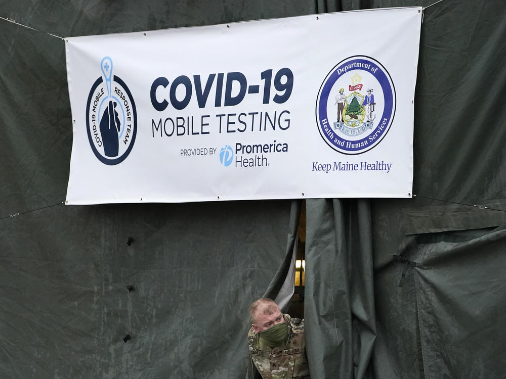 A member of the National Guard assisting at a COVID-19 mobile testing location looks out of a tent used for drive-thru tests earlier this month in Auburn, Maine.
