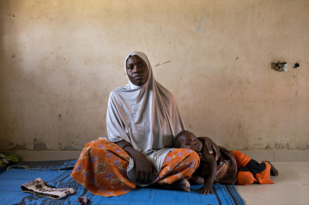 Halima Ibrahim, 30, with her daughter. After her village was attacked, Ibrahim was forced to live under Boko Haram rule for nine months in Monguno, Nigeria, where insurgents would threaten to kill people in front of them as intimidation. After the military rescued people in captivity, she reunited with her husband in Maiduguri, where she lives in a refugee camp with him and their children.