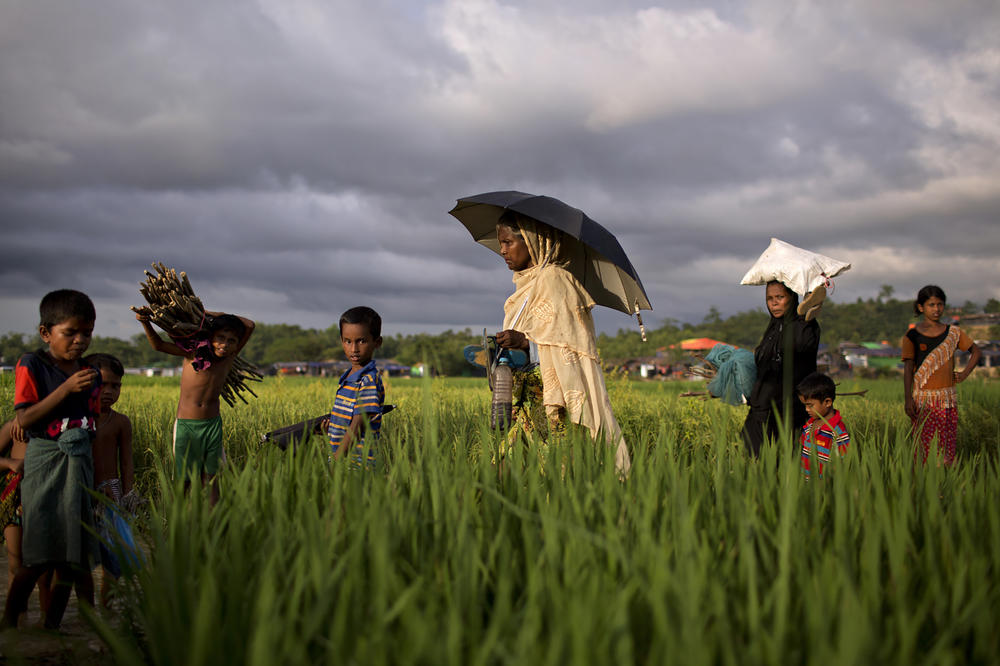 Rohingya women and children walk through a refugee camp outside of Cox's Bazar, Bangladesh, where nearly one million people have taken refuge, many with visible wounds and scars from human rights abuses committed against them in Myanmar.