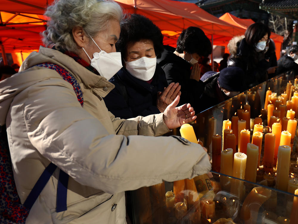 South Koreans pray for their children taking the College Scholastic Ability Test at Chogey temple in Seoul on Thursday. New coronavirus infections in the country have spiked in recent days.