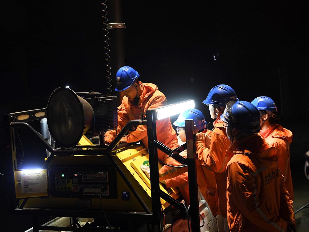 Rescuers adjust an emergency generator at the Diaoshuidong coal mine in southwest China on Saturday after a carbon monoxide leak at the facility left 23 dead.