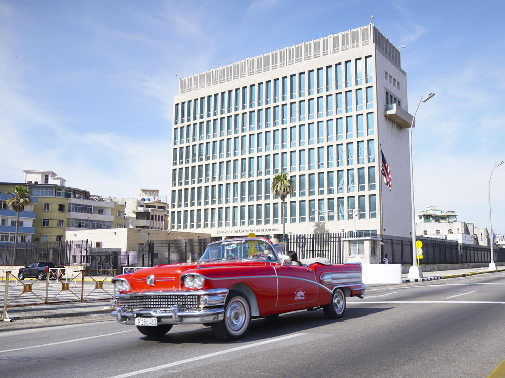 A car drives past the U.S. Embassy in Havana in 2019. Dozens of Americans working at U.S. diplomatic missions in Cuba and China in recent years have suffered from ailments that have included headaches, balance problems and memory loss.