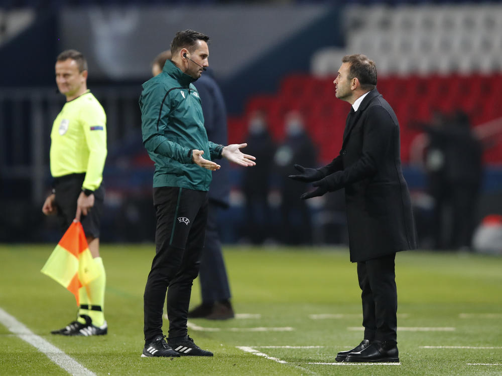 Basaksehir team manager Okan Buruk (right) argues with referee Sebastian Coltescu during a Champions League soccer match between Paris Saint Germain and Istanbul Basaksehir in Paris on Tuesday.