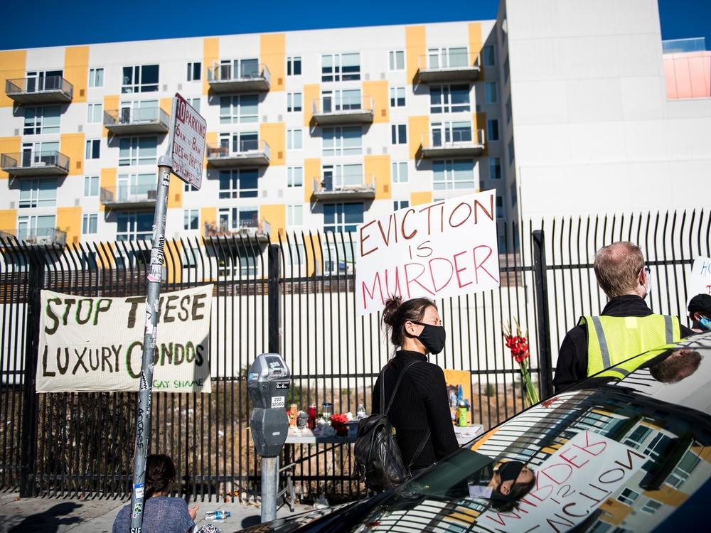 A demonstrator holds a sign in the Mission in San Francisco on Nov, 16 calling for shelter-in-place hotel rooms to remain available for unhoused residents.