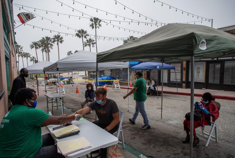 Homeless people wait to be checked-in to a hotel room in Venice Beach, Calif., on April 26. The NGO St. Joseph Center is providing Hotel rooms to the homeless people at risk or infected with COVID-19, through Project Roomkey of the City of Los Angeles.