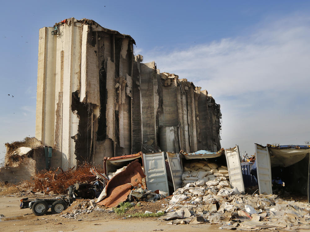 Shattered containers remain in front of towering grain silos gutted in the August explosion at the Beirut port that claimed the lives of more than 200 people.