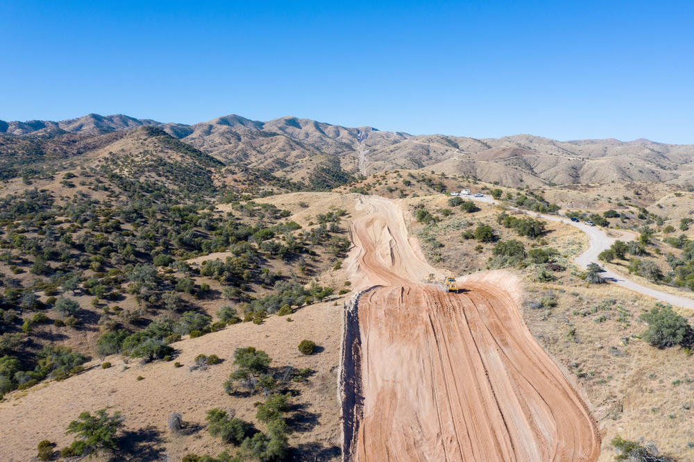Heavy equipment is clearing a path for the border wall next to  Coronado National Forest in Southern Arizona. Mexico is on the left.