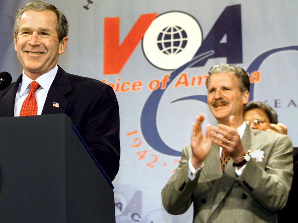 Robert R. Reilly led Voice of America briefly under President George W. Bush. Here they're shown at a VOA anniversary celebration in February 2002.
