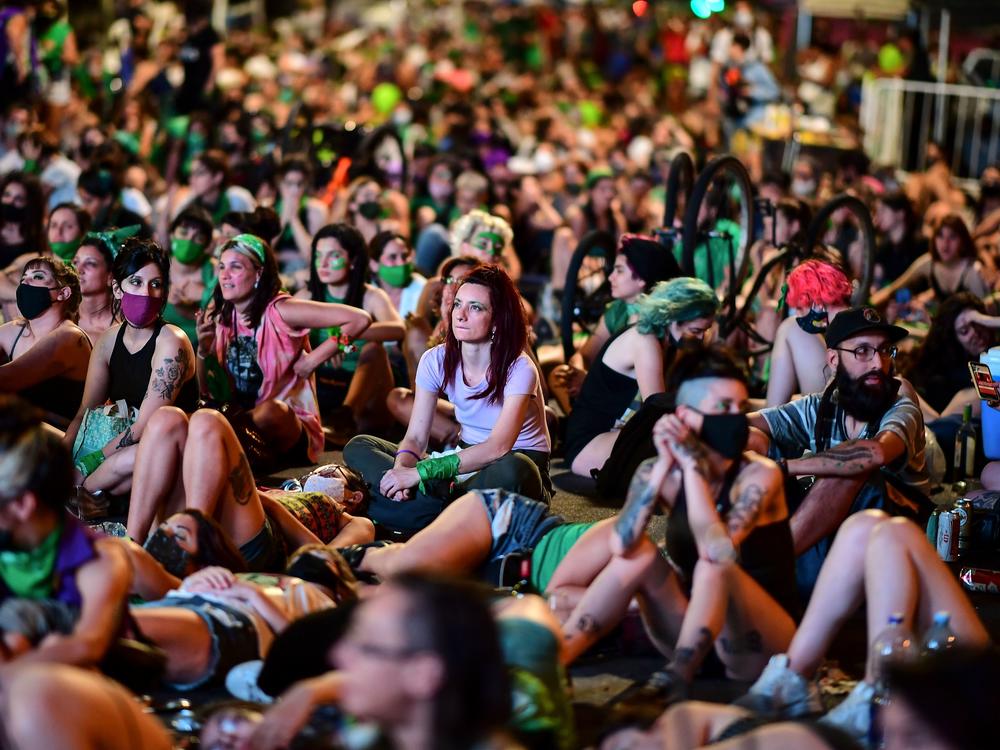 Demonstrators wait with green headscarves — the symbol of abortion rights activists — outside the Argentine Congress in Buenos Aires, where lawmakers endorsed a bill to legalize abortion
