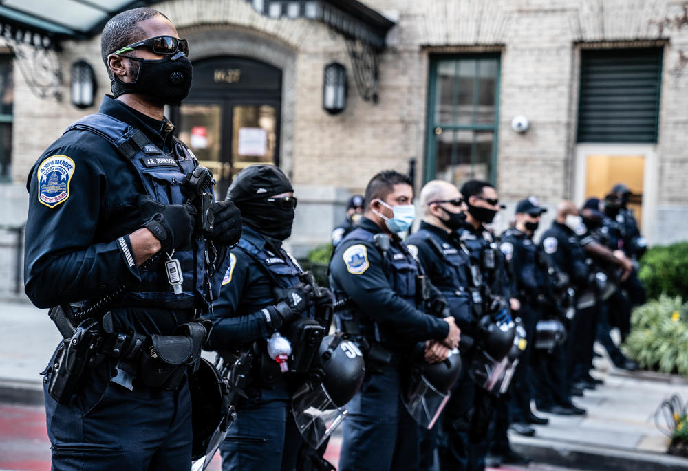 Police officers create a line between Trump supporters and counterprotesters.