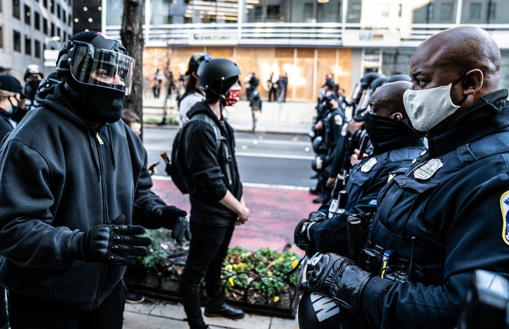 A counterprotester talks with a police officer, saying police are protecting Trump supporters and not counterprotesters.