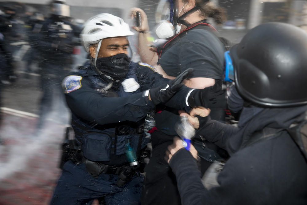 Police scuffle with counterprotesters during a confrontation at Black Lives Matter Plaza.