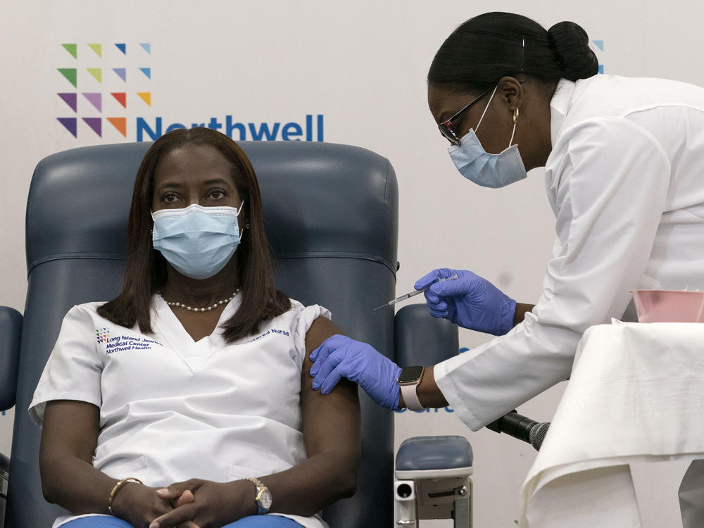 Sandra Lindsay (left) a nurse at Long Island Jewish Medical Center, is inoculated with the Pfizer-BioNTech COVID-19 vaccine by Dr. Michelle Chester on Monday in New York.