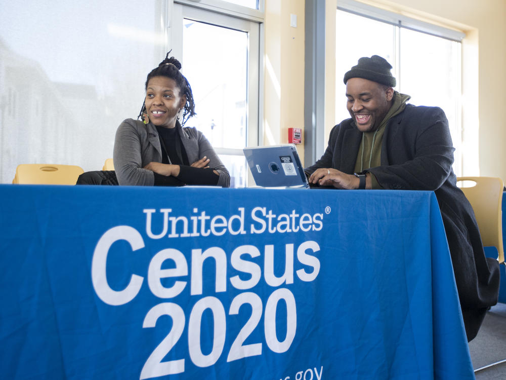 Chris Worrell jokes with Teresa Jefferson while applying for a 2020 census job in Boston in February before the COVID-19 pandemic. Based on government records, the Census Bureau estimates the U.S. population has grown by as much as 8.7% since 2010.