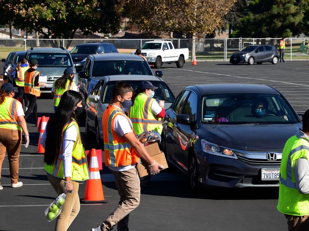 Food is loaded as drivers in their vehicles wait in line at a food distribution hosted by the Los Angeles Food Bank on Dec. 4 in Hacienda Heights, Calif.