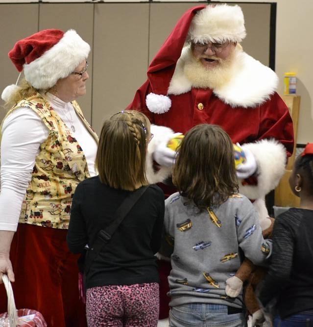 Santa and Mrs. Claus show presents to children at the 2019 Autism Canadian Valley Christmas party in Yukon, Okla.