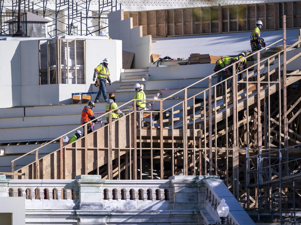 Construction crews work on the platforms where President-elect Joe Biden will take the oath of office at the Capitol in Washington.