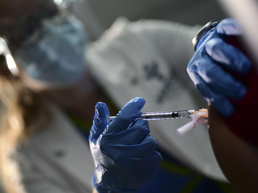 Nurse Melissa Valentin applies the Pfizer-BioNTech COVID-19 vaccine to a health worker at the Ashford Presbyterian Community Hospital in San Juan, Puerto Rico, Tuesday. The vaccine was granted emergency use authorization last week.