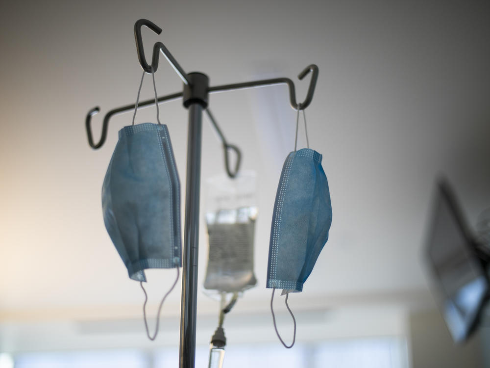 Masks hang from an IV pole at a hospital.