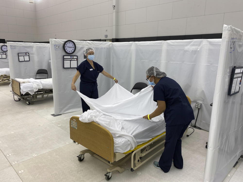 Hospital beds are set up in the practice facility at Sleep Train Arena in Sacramento, Calif. The facility is ready to receive patients as needed as new coronavirus infections and deaths rise in the state.