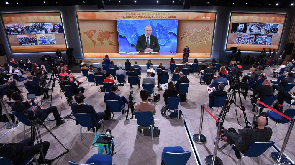 Journalists gather in front of a big screen in Moscow for Russian President Vladimir Putin's annual news conference Thursday. Questions were piped in remotely from journalists throughout the country.