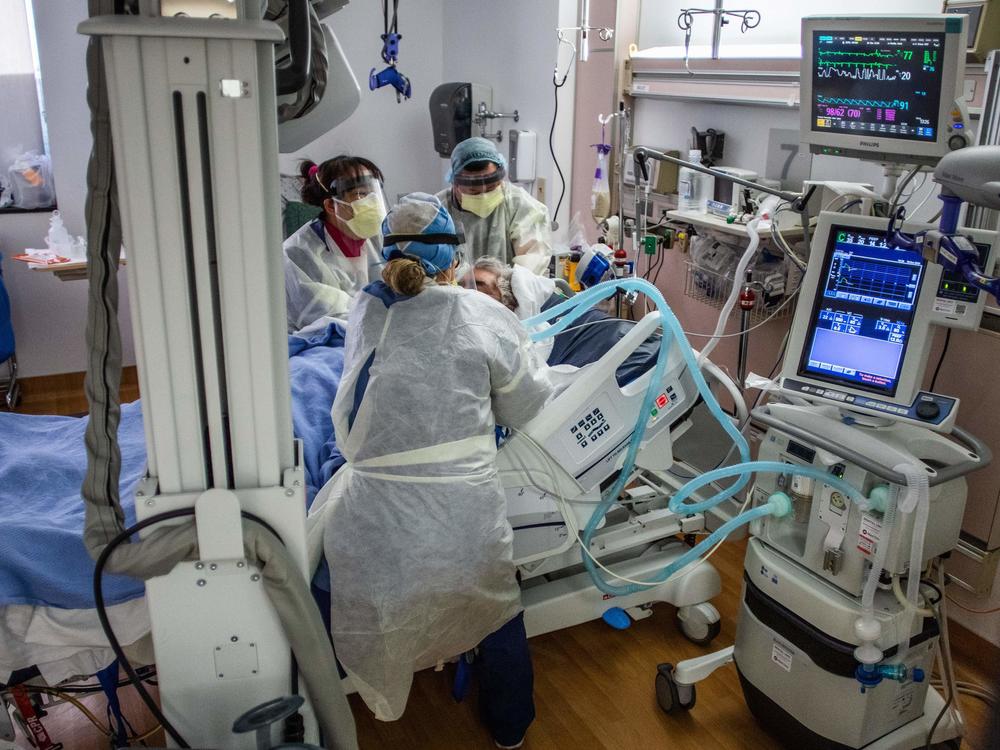 Physicians and nurses wear personal protective equipment while they attend to a COVID-19 patient in the ICU at Providence Cedars-Sinai Tarzana Medical Center in Tarzana, Calif. on December 18, 2020.