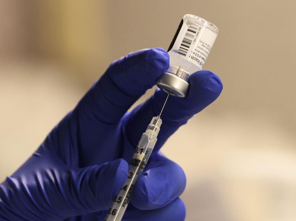 A pharmacist fills a syringe to prepare a dose of the Pfizer-BioNTech vaccine for front-line health care workers in Torrance, Calif., on Saturday. A panel of CDC advisers said people 75 and older and some essential workers should be next in line.