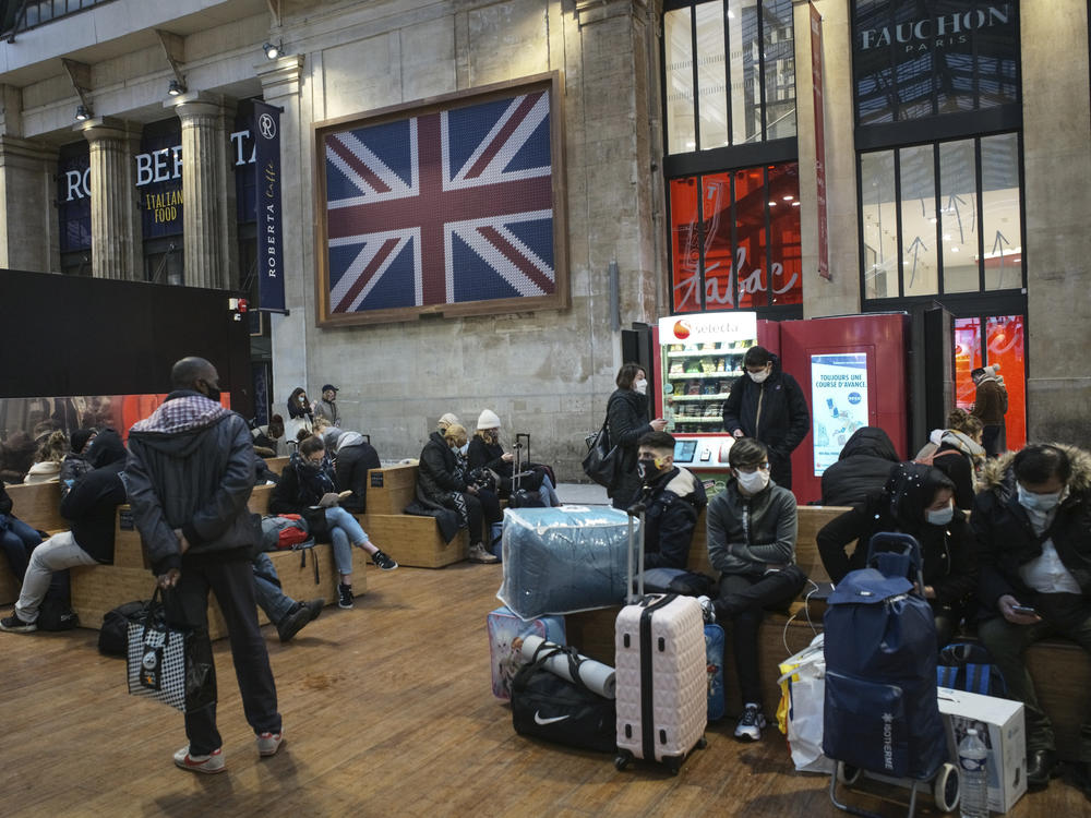 Passengers wearing face masks wait next to the Eurostar Terminal at Gare du Nord train station in Paris on Monday. France is banning all travel from the U.K. for 48 hours in an attempt to make sure a new strain of the coronavirus in Britain doesn't reach its shores.