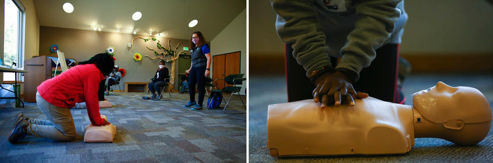 (Left) Joy Eloi, 14, and Jan Garduno (right) practice compressions on a CPR training mannequin during the first-aid class for hikers.