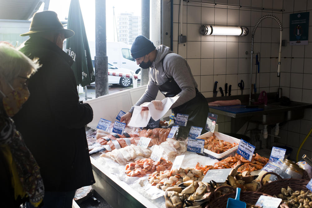 Benoit Celino sells fish to a customer at the fish market in Boulogne-sur-Mer.