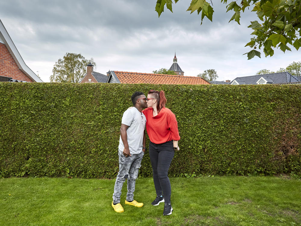 Patrick Phiri of Malawi and fiance Fiona ten Have of Holland kiss in her parents' garden. The couple met in Malawi, where they worked for the same charity, and fell in love. A 3-week visit to the Netherlands turned into 7 months due to pandemic lockdowns and travel restrictions.