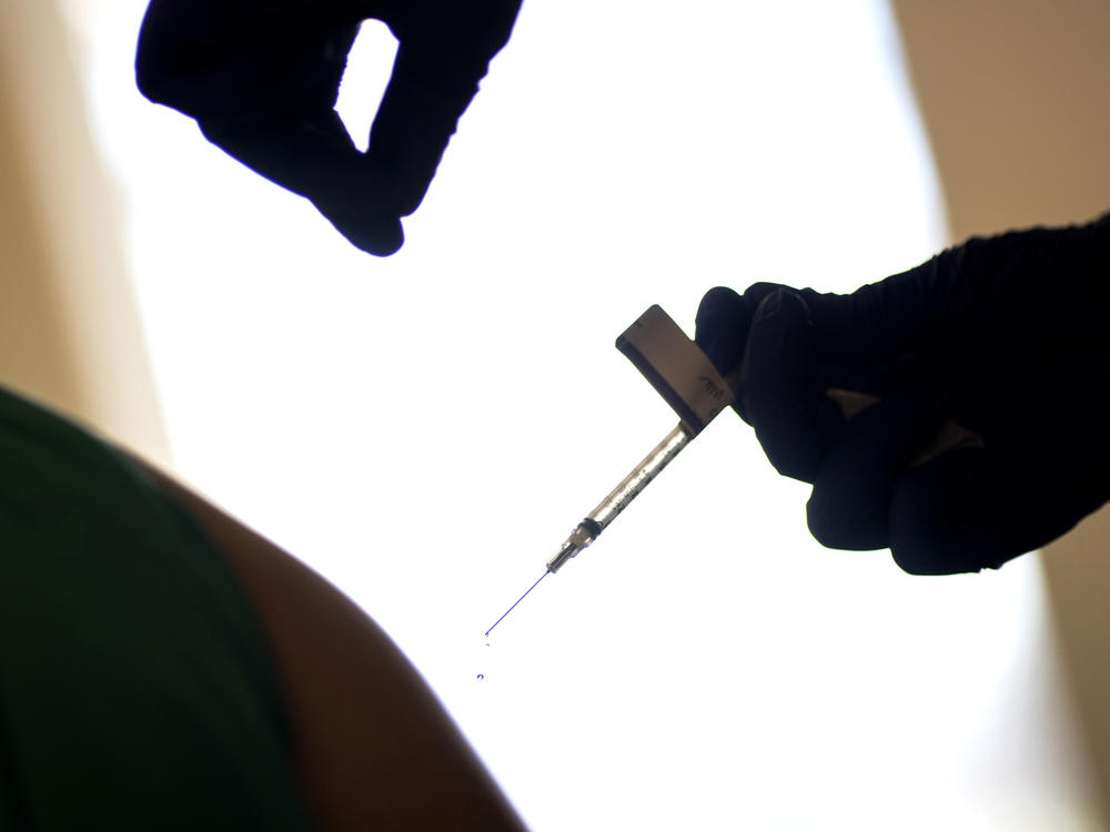 A droplet falls from a syringe after a health care worker was injected with the Pfizer-BioNTech COVID-19 vaccine at Women & Infants Hospital in Providence, R.I.