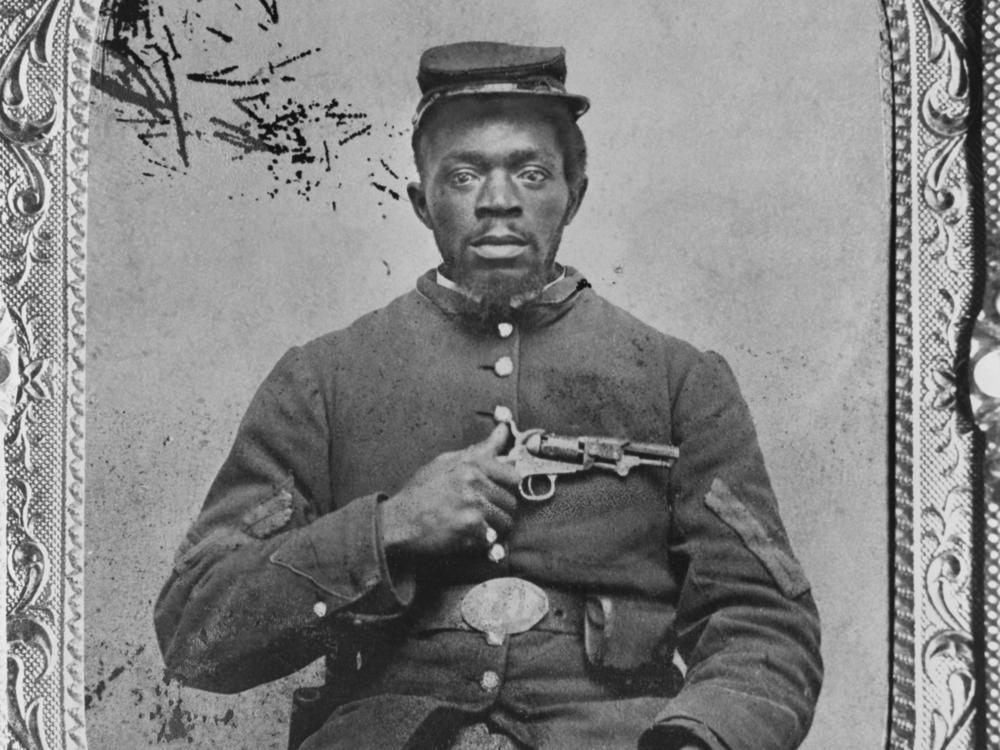 Negro Union Infantry corporal, holding a Colt model 1849 pocket revolver.