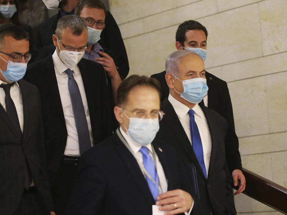 Israeli Prime Minister Benjamin Netanyahu (center) wears a protective face mask as he makes his way to attend the swearing-in ceremony of his new government, at the Knesset, Israel's parliament, in May. The Knesset has dissolved and Israel is headed to new elections for the fourth time in two years.