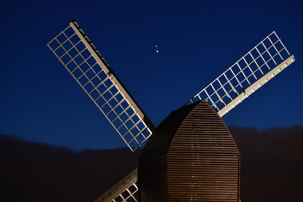 Jupiter and Saturn are seen coming together in the night sky, over the sails of Brill windmill in Brill, England.