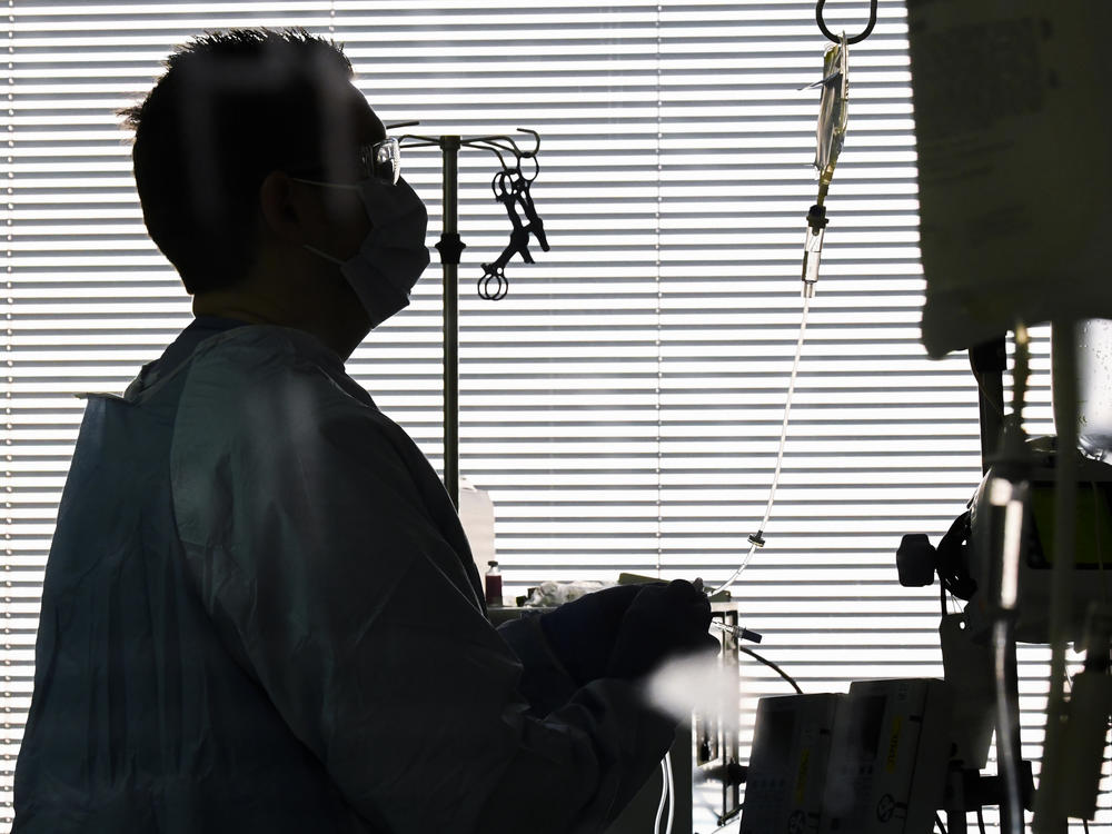 East Alabama Medical Center nurse Harvard Graham checks fluids for a COVID-19 patient in the intensive care unit this month in Opelika, Ala.