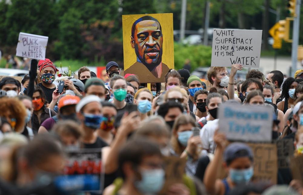 A protester holds up a portrait of George Floyd during a 
