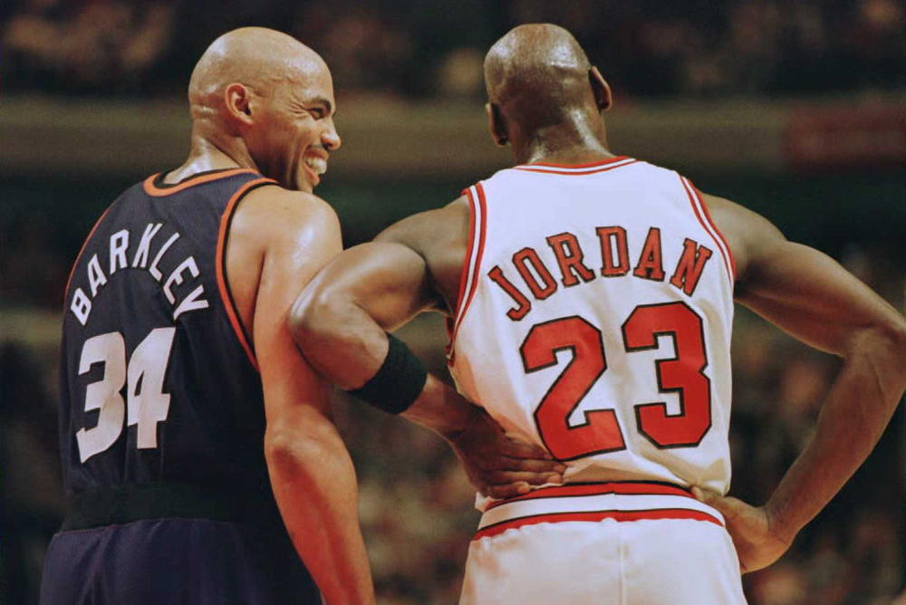 Charles Barkley, left, laughs with Chicago Bulls guard Michael Jordan during a game in Chicago in January 1996.