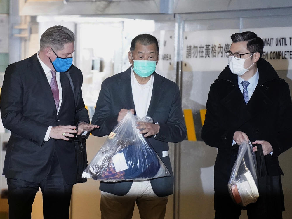 Hong Kong pro-democracy activist and media tycoon Jimmy Lai, center, walks out of court with his lawyers after being granted bail Wednesday, nearly three weeks after he was arrested over fraud and national security-related charges.