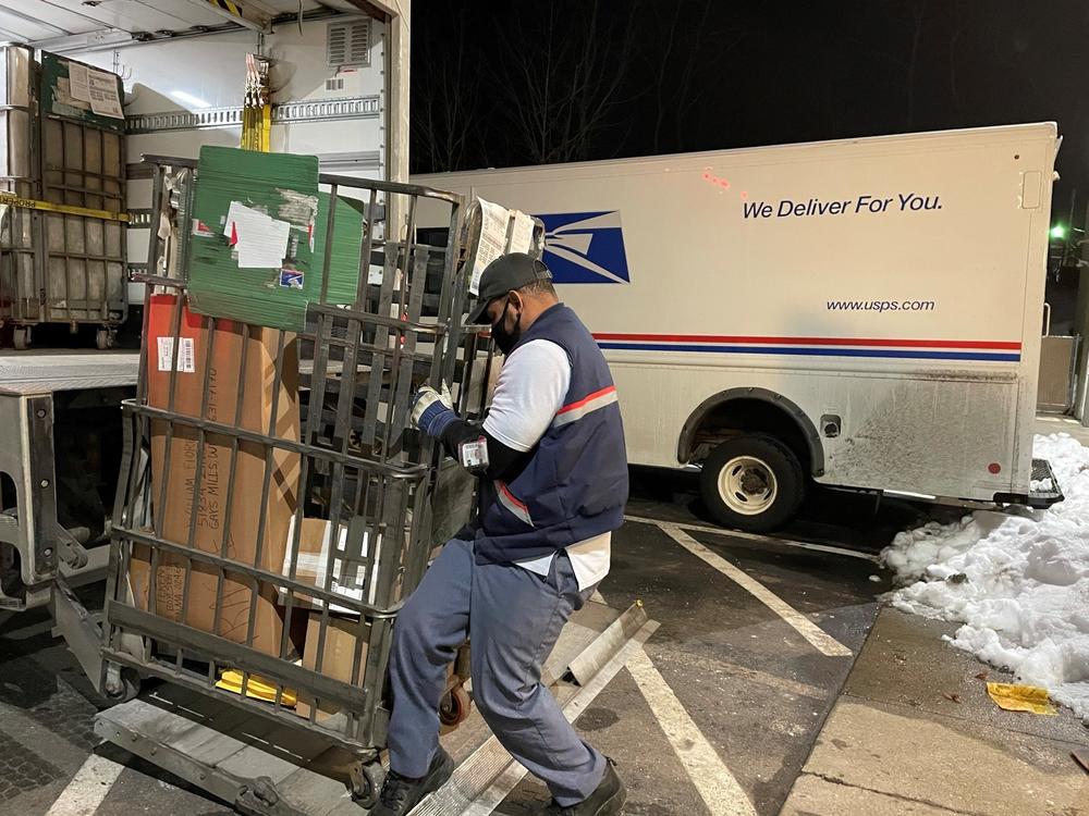 Like many of his colleagues, postal worker Rickey Ramirez is working overtime to keep up with the crush of Christmas deliveries. Many packages are likely to be delivered after Dec. 25.
