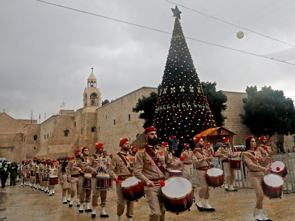 A Palestinian scouts band parades in front of the Church of the Nativity during Christmas celebrations in Bethlehem in the occupied West Bank, on Dec. 24, 2020. Annual festivities around the Church of the Nativity were scaled back but Bethlehem residents were intent on maintaining traditions.