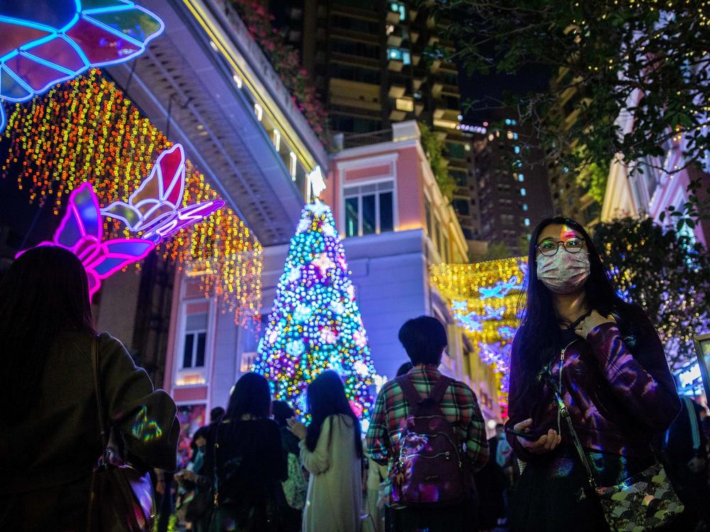 People wearing face masks walk past a Christmas display at a shopping mall in the Wanchai district of Hong Kong on Dec. 24, 2020.