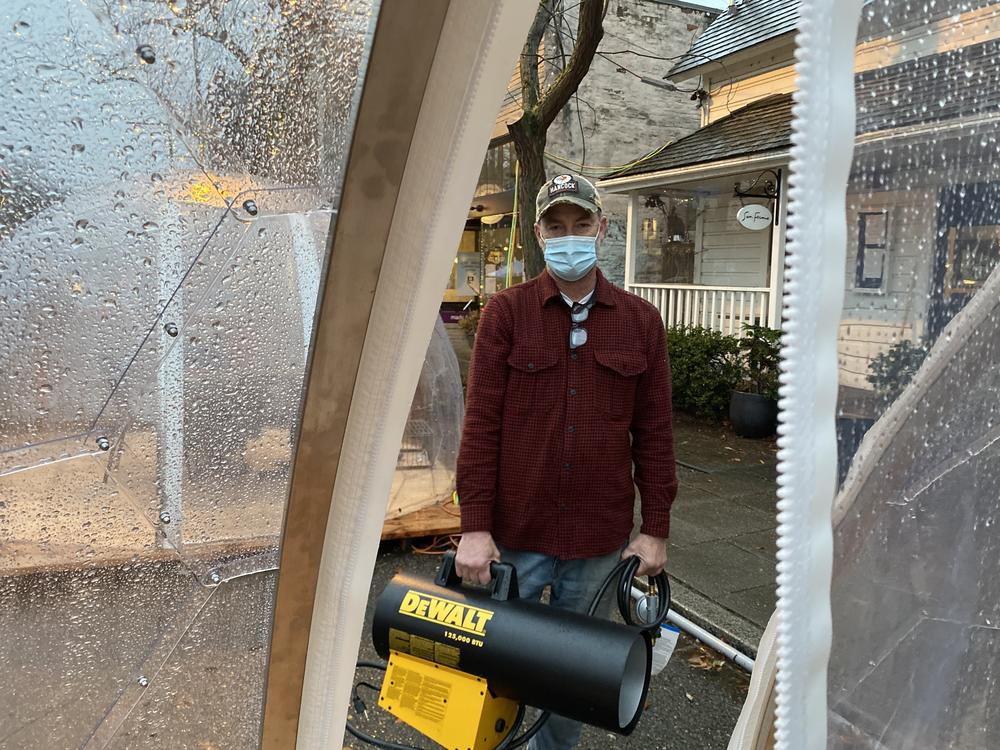 Tim Baker, owner of Seattle's San Fermo, holds a hot air cannon he uses inside the dining igloos ahead of each seating. After a thorough ventilation, the device warms up the interior, he says, and also helps disperse any lingering infectious particles.